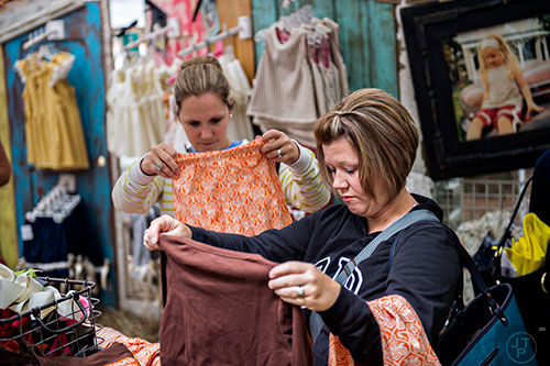 Kim Cooke (right) and Kerri Carter look at clothes inside the Smartie Britches booth during the Yellow Daisy Festival at Stone Mountain Park on Saturday, September 12, 2015. 