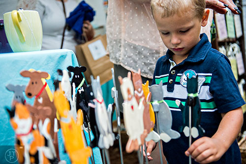Ryley Jordan checks out a cat on a stick at one of the booths at the Yellow Daisy Festival at Stone Mountain Park on Saturday, September 12, 2015. 