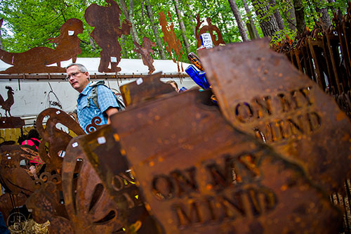 Byron Beam looks at the yard art on display in one of the booths at the Yellow Daisy Festival at Stone Mountain Park on Saturday, September 12, 2015.