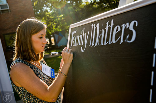 Kathryn Ethridge writes on a chalkboard before the start of the Families First groundbreaking ceremony at the historic E.R. Carter Elementary School in Atlanta on Thursday, September 17, 2015. 