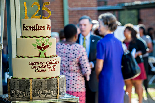 Supporters congregate near the cake celebrating the 125 years of service for the Families First organization  before the start of the groundbreaking ceremony at the historic E.R. Carter Elementary School in Atlanta on Thursday, September 17, 2015.  