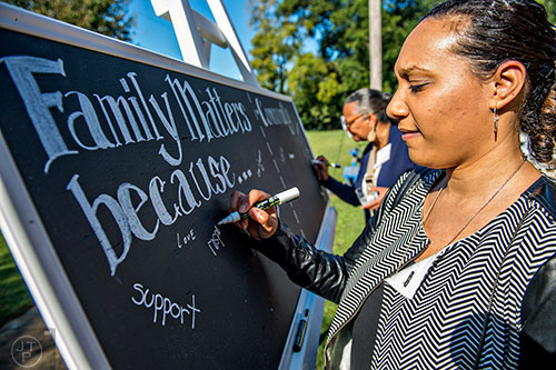 Nasim Fluker (right) and Robyn Sims fill in why family and community matter to them before the start of the Families First groundbreaking ceremony at the historic E.R. Carter Elementary School in Atlanta on Thursday, September 17, 2015.  
