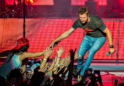 Dierks Bentley reaches out to the crowd as he performs on stage at Verizon Wireless Amphitheatre in Alpharetta during the 94.9 The Bull's Big Country Fan Jam on Saturday, September 19, 2015.  