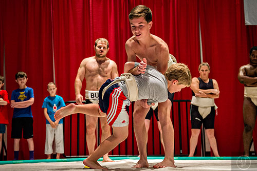Carter Gable (top) throws Garrett Bannevans out of the ring in a sumo wrestling demonstration during JapanFest at the Infinite Energy Center in Duluth on Saturday, September 19, 2015.  