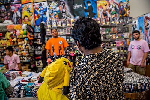 Reyna Ghoshal (left) leans against her father Rudro as they shop in Anime Village during JapanFest at the Infinite Energy Center in Duluth on Saturday, September 19, 2015.  