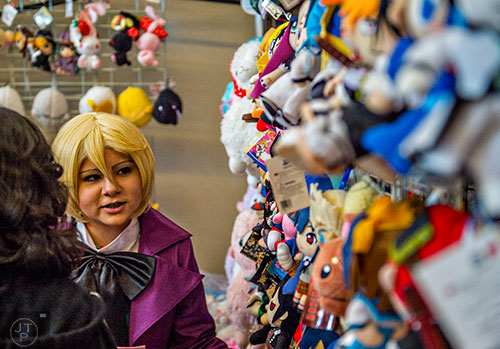 Erica Crews (center) looks at plush anime character dolls during JapanFest at the Infinite Energy Center in Duluth on Saturday, September 19, 2015.  