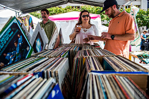 Chad Norton (right) and his wife Heather look at vinyl records in Gene Curtain's booth during the Marietta StreetFest in the historic downtown square on Saturday, September 19, 2015. 