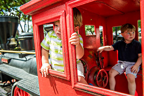 Ash Hatcher (left) and Zachary Harris play in the train engine in the historic downtown square during the Marietta StreetFest on Saturday, September 19, 2015. 