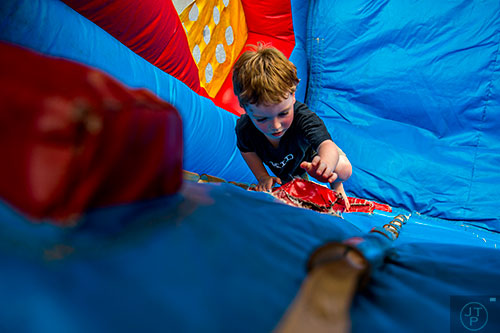 Jeremy Bromell climbs an inflatable obstacle course during the Marietta StreetFest in the historic downtown square on Saturday, September 19, 2015.  