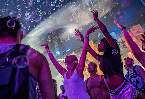 Katharina Godmasch (left) and Christelle Mengue reach for the bubbles that fly from the stage during TomorrowWorld in Chattahoochee Hills on Saturday, September 26, 2015. 