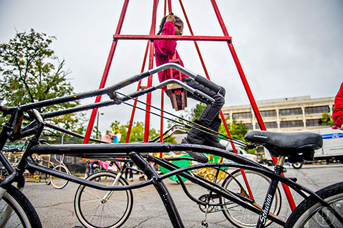 Kiara Demmons rides a dual bike contraption during the Atlanta Maker Faire in Decatur on Saturday, October 3, 2015. 