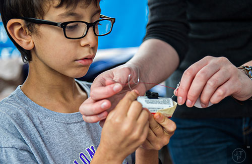 Justice Nessman (left) makes his own motor during the Atlanta Maker Faire in Decatur on Saturday, October 3, 2015. 