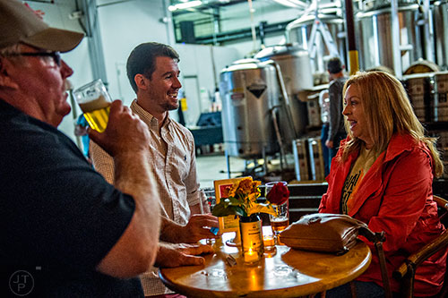 Dick Zinkie (left) takes a sip of beer as Nick McMillan talks with Patsy Zinkie during the Second Self Beer Company's one year anniversary celebration in Atlanta on Saturday, October 3, 2015. 