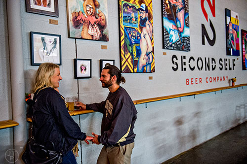 Kimberly Tokars (left) holds hands with Kenny Mills during the Second Self Beer Company's one year anniversary celebration in Atlanta on Saturday, October 3, 2015. 