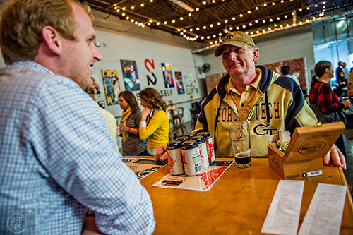 George Burdell (right) talks with Alex Kaas as he tries beers in the tasting room during the Second Self Beer Company's one year anniversary celebration in Atlanta on Saturday, October 3, 2015. 