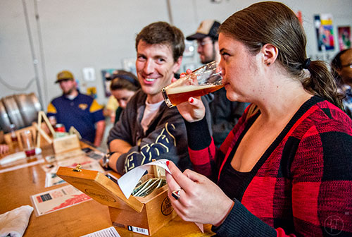 Shannon McKnight (right) tries her beer as she talks with Geoff Warr during the Second Self Beer Company's one year anniversary celebration in Atlanta on Saturday, October 3, 2015. 