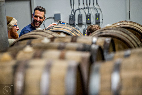 Andrew Zinkie (left) talks with Jay Propst near the stack of casks during the Second Self Beer Company's one year anniversary celebration in Atlanta on Saturday, October 3, 2015. 