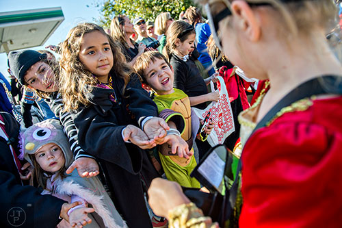 Stella Maximuk (left) and her brother Nico reach their hands out to try and get candy during the Little Five Points Halloween Parade in Atlanta on Saturday, October 17, 2015. 