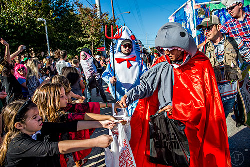 Adam Moore (right) passes out candy during the Little Five Points Halloween Parade in Atlanta on Saturday, October 17, 2015. 