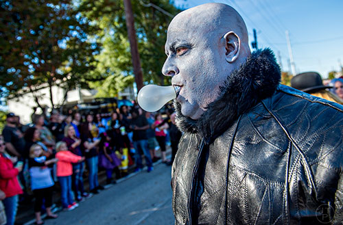 Dressed as Uncle Fester from the Addams Family, Arthur Morrison carries a lightbulb in his mouth during the Little Five Points Halloween Parade in Atlanta on Saturday, October 17, 2015. 