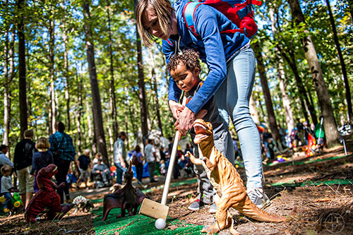 Caitlin Lucas (right) helps her son Rohan play a game of golf during the 43rd annual Highland Games at Stone Mountain Park on Saturday, October 17, 2015. 