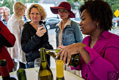 Natalie Richardson (right) pours a glass of wine for Virginia Vicory and Rebecca Bowden during the Kirkwood Wine Stroll on Friday. 