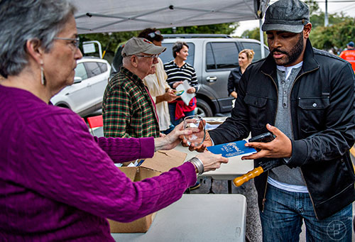 Kali Alford (right) takes his wine glass and booklet from Carol Kobayashi during the Kirkwood Wine Stroll on Friday. 