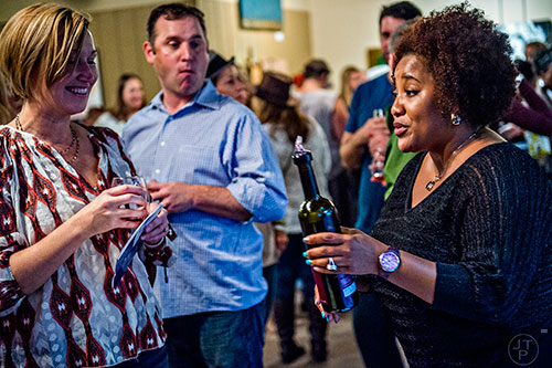 Cassandra Loftlin (right) talks with Caroline Taylor as she pours wine during the Kirkwood Wine Stroll on Friday. 