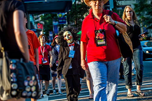 Dressed as the puppet from the Saw movies, Dylan Mason walks down Peachtree St. before the start of the annual DragonCon Parade in Atlanta on Saturday, September 5, 2015.