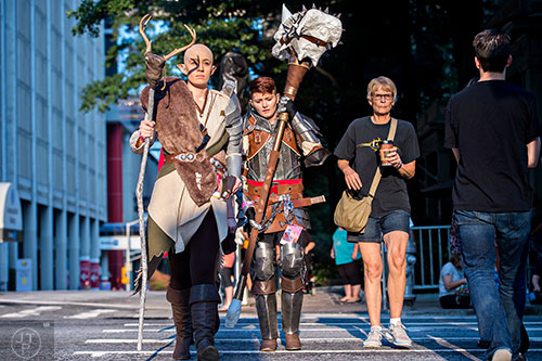Abi Penrod (left) and Tobie Sidell cross Peachtree St. as they make their way to the staging area for the annual DragonCon Parade in Atlanta on Saturday. 