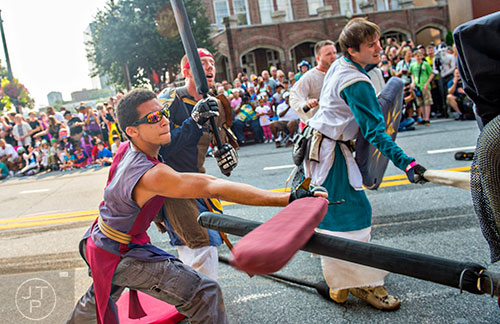 Ryan Tennyson (left) lunges to attack with his sword as he battles down Peachtree St. during the annual DragonCon Parade in Atlanta on Saturday, September 5, 2015.