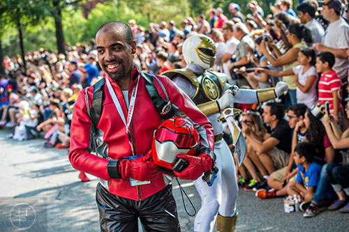 Dressed as a Power Ranger, Daniel Plunkett smiles as he walks back from the crowd during the annual DragonCon Parade in Atlanta on Saturday, September 5, 2015.