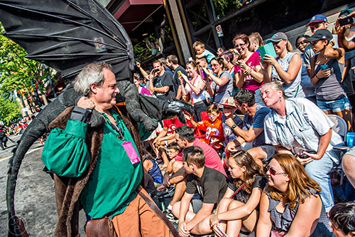 Chris Lopresto works his dragon puppet for the crowd during the annual DragonCon Parade in Atlanta on Saturday.