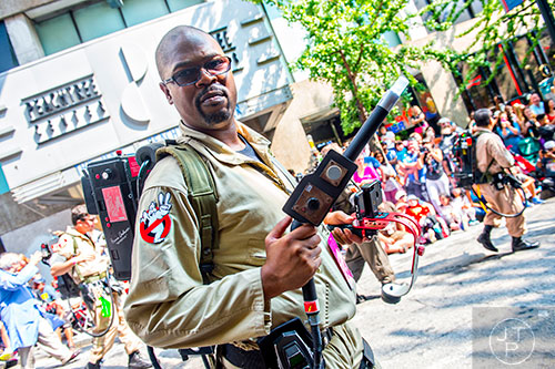 Dressed as a Ghostbuster, Mitchell Brinkley pulls out his proton gun as he marches in the annual DragonCon Parade in Atlanta on Saturday, September 5, 2015.