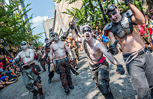 Dressed as a War Boy from Mad Max Fury Road, Jeff Basladyhski (center right) charges down the street during the annual DragonCon Parade in Atlanta on Saturday, September 5, 2015.