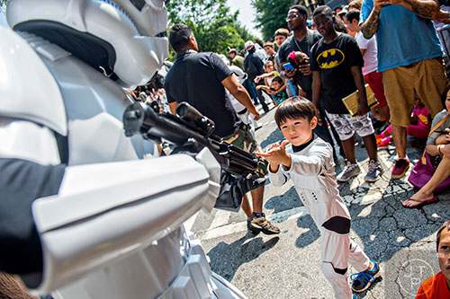 Dressed as a storm trooper, five-year-old Kane Bennett (right) asks for a fellow storm troopers' weapon as they march down the street during the annual DragonCon Parade in Atlanta on Saturday, September 5, 2015.