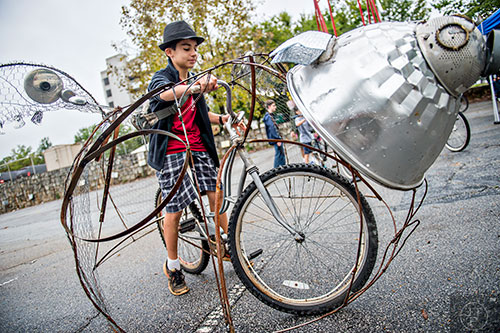 Garrett Hinton rides a bicycle made to look like a flying pig during the Atlanta Maker Faire in Decatur on Saturday.