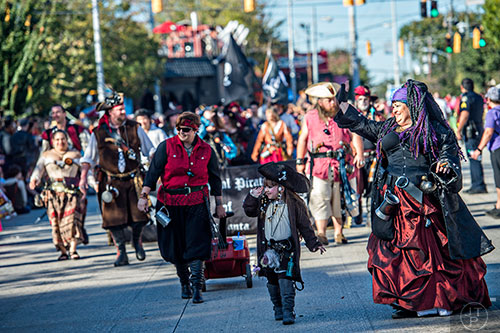 Dressed as pirates, Haley Apley (center) and Selena Copeland wave to the crowd during the Little Five Points Halloween Parade on Saturday, October 17, 2015.