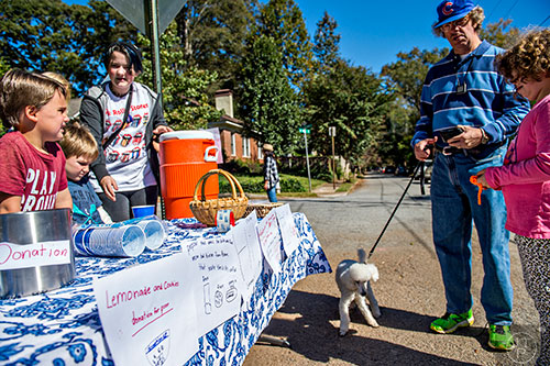Maya Goren (right) and her father Bill get a glass of lemonade from Kat Butler and Kieran Dickmann as they raise money for a charity during the Oakhurst Porch Fest on Sunday.