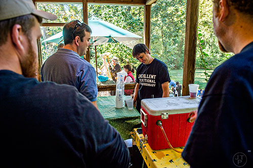 DeSha Dean (center) pours free beer during the Oakhurst Porch Fest on Sunday.
