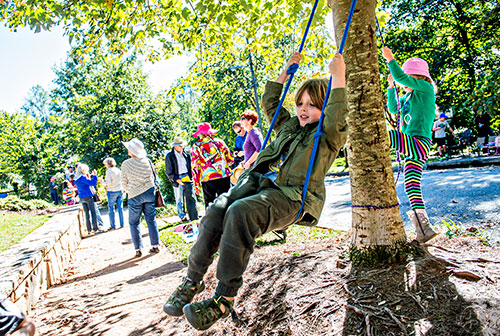 Emmett Helton swings on a tree during the Oakhurst Porch Fest on Sunday.