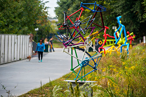 Sean Mueller's "The Bicycle Tower" and Beju Lejobart's "It's a Tie" can be seen as people pass by the installations for Art on the Beltline.