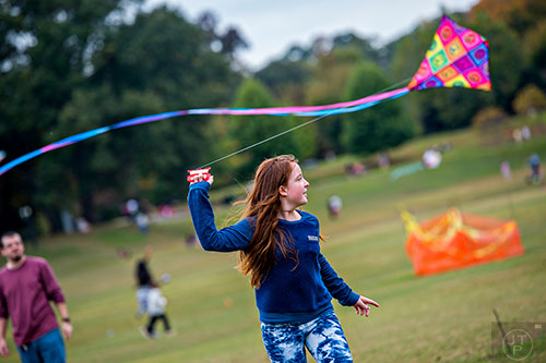 Cecilia Rigogliosi runs with her kite during the Atlanta World Kite Festival at Piedmont Park on Saturday, October 24, 2015. 