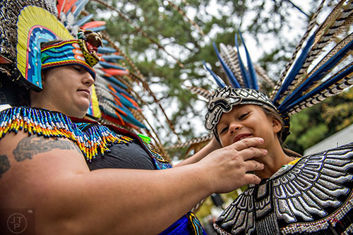 Felicia Alfaro (left) helps her daughter Aaliyah with her headdress during the Indian Festival & Pow Wow at Stone Mountain Park on Saturday, October 31, 2015. 