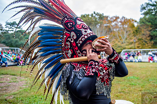 Javier Alfaro blows into a conch shell during the Indian Festival & Pow Wow at Stone Mountain Park on Saturday, October 31, 2015. 