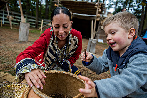 Liam Lindblad (right) helps Jessica Diemer-Eaton shuck beans during the Indian Festival & Pow Wow at Stone Mountain Park on Saturday, October 31, 2015. 