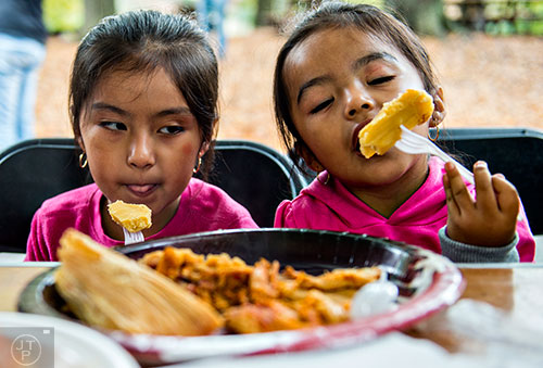 Melanie Flores (left) and her sister Mia eat tamales during the Dia De Muertos, or Day of the Dead, Festival at the Atlanta History Center on Sunday, November 1, 2015. 
