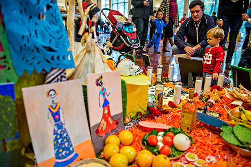 Jay Roby (left) explains the candles, food, pictures and other decorations to his son Ryan during the Dia De Muertos, or Day of the Dead, Festival at the Atlanta History Center on Sunday, November 1, 2015. 
