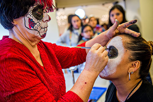 Robbin Roling (left) paints Linda Ibarra's face during the Dia De Muertos, or Day of the Dead, Festival at the Atlanta History Center on Sunday, November 1, 2015. 