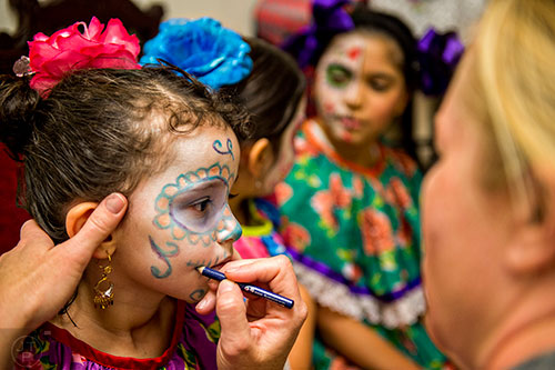 Lucia Lev (left) has her makeup touched up before dancing on stage during the Dia De Muertos, or Day of the Dead, Festival at the Atlanta History Center on Sunday, November 1, 2015. 